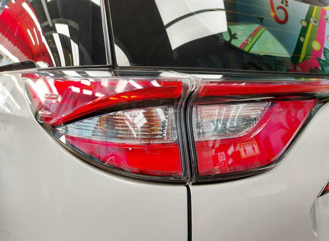 The coated bonnet of the Toyota Previa Aeras under workshop lighting.