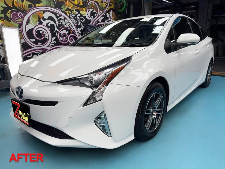 Finished white Toyota Prius from the front three-quarter in the workshop, with a small AFTER label in the corner.