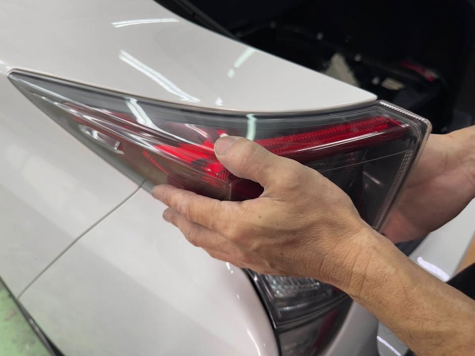 Tail light being lifted out of the rear quarter.