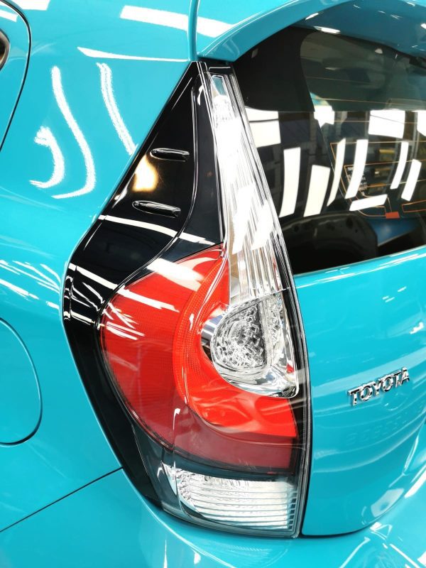 The coated bonnet of the Toyota Prius under workshop lighting.