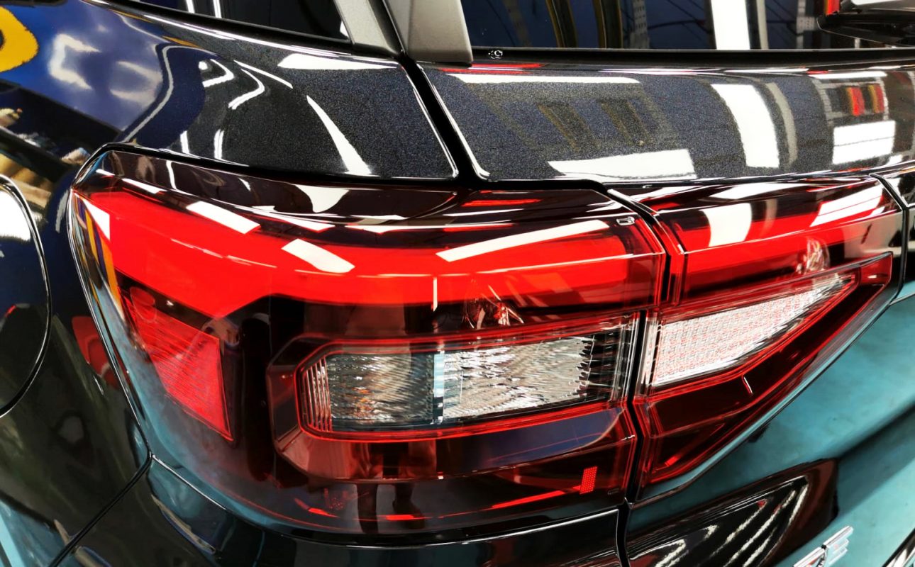 The coated bonnet of the Toyota Raize under workshop lighting.