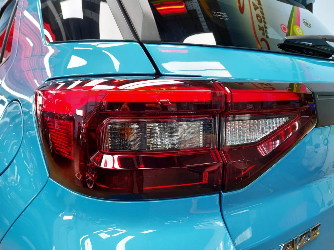 The coated bonnet of the Toyota Raize under workshop lighting.