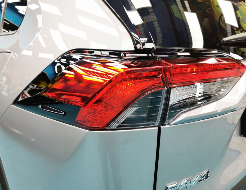 The coated bonnet of the Toyota RAV4 under workshop lighting.