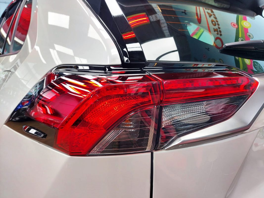 The coated bonnet of the Toyota RAV4 under workshop lighting.
