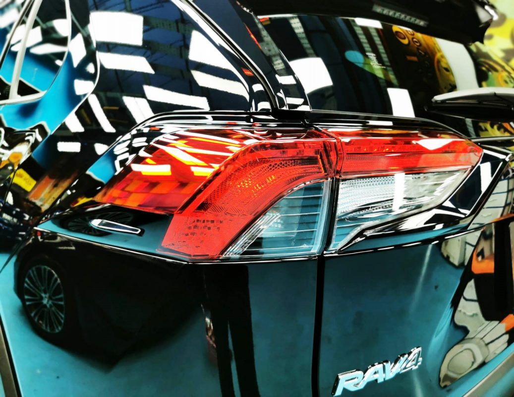The coated bonnet of the Toyota RAV4 under workshop lighting.