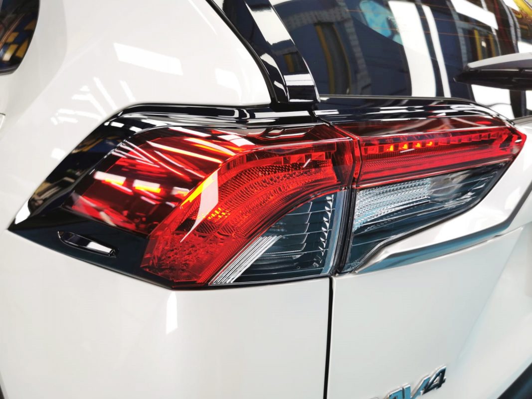 The coated bonnet of the Toyota RAV4 under workshop lighting.