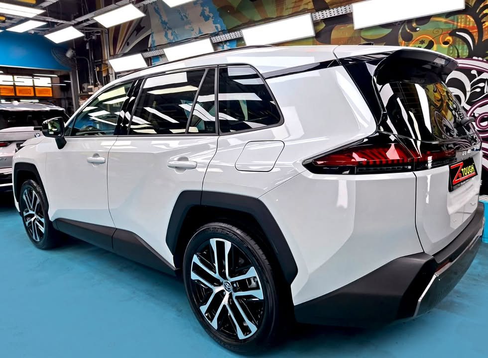 Rear three-quarter view of the white Toyota RAV4 with black roof and two-tone alloy wheel.