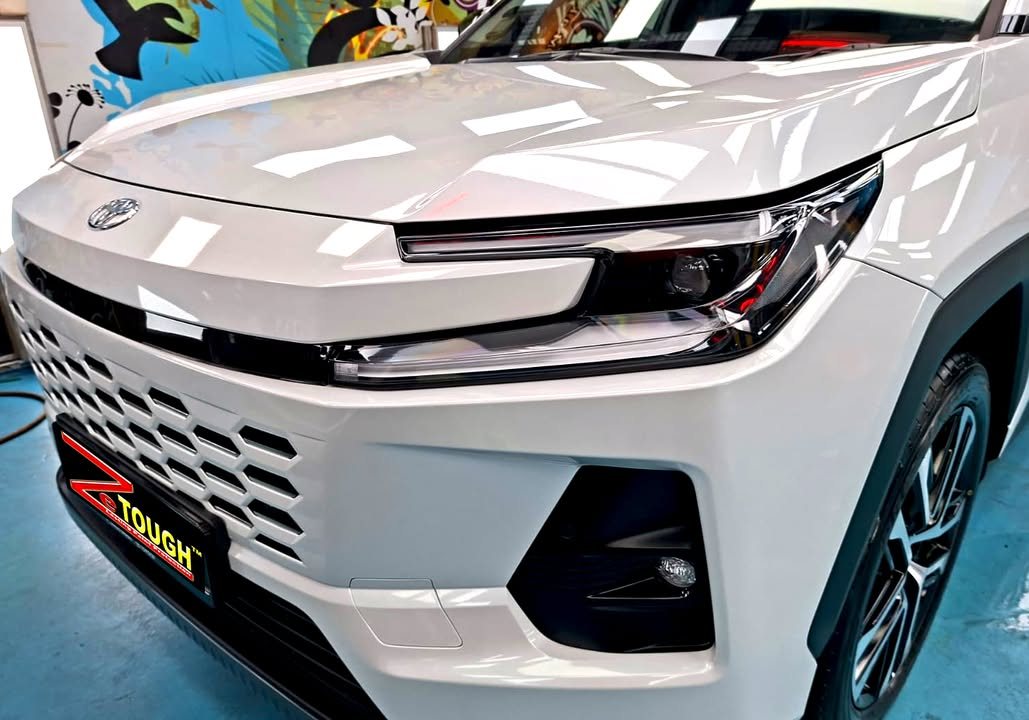White bonnet and front grille of the RAV4 reflecting the workshop lights.