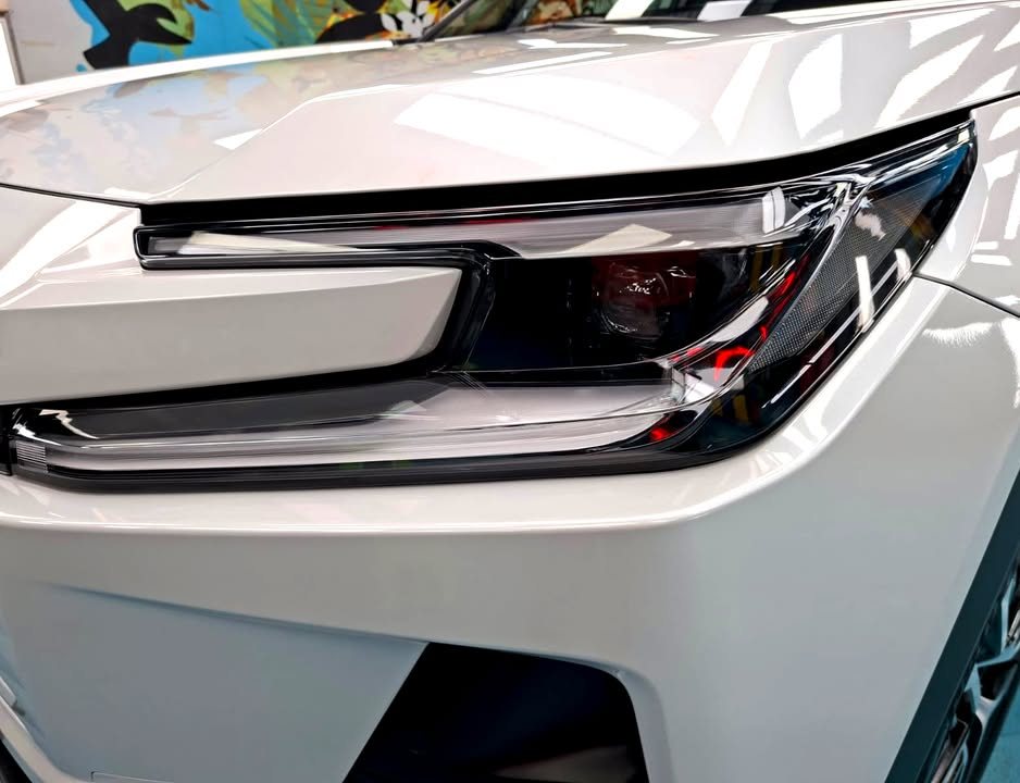 Close-up of the RAV4 headlamp beside the white front wing.