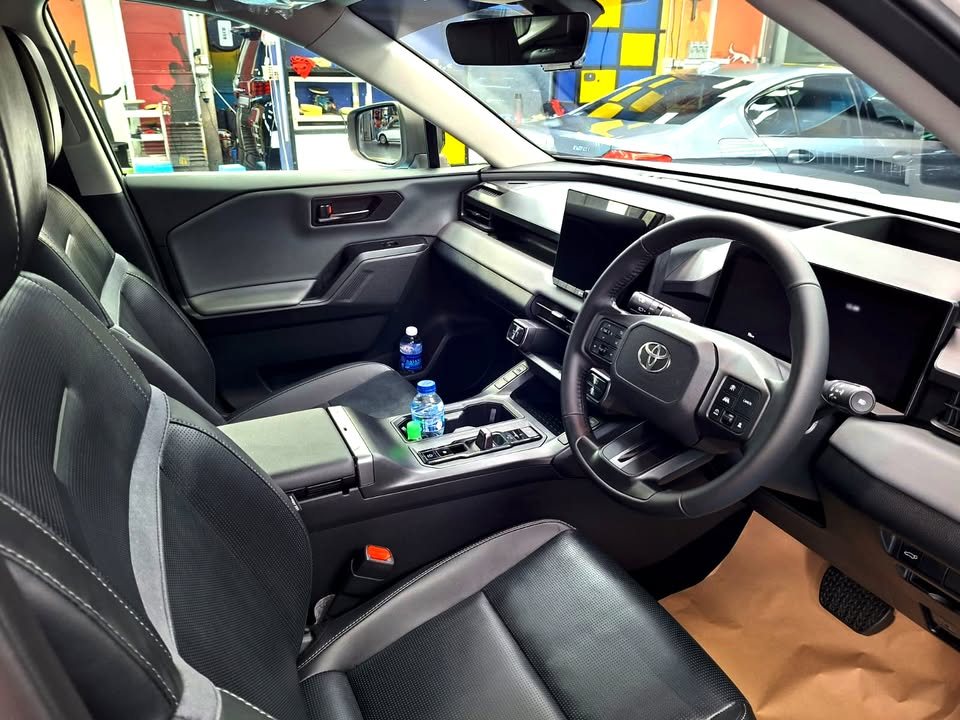 RAV4 interior with black leather seats and steering wheel.