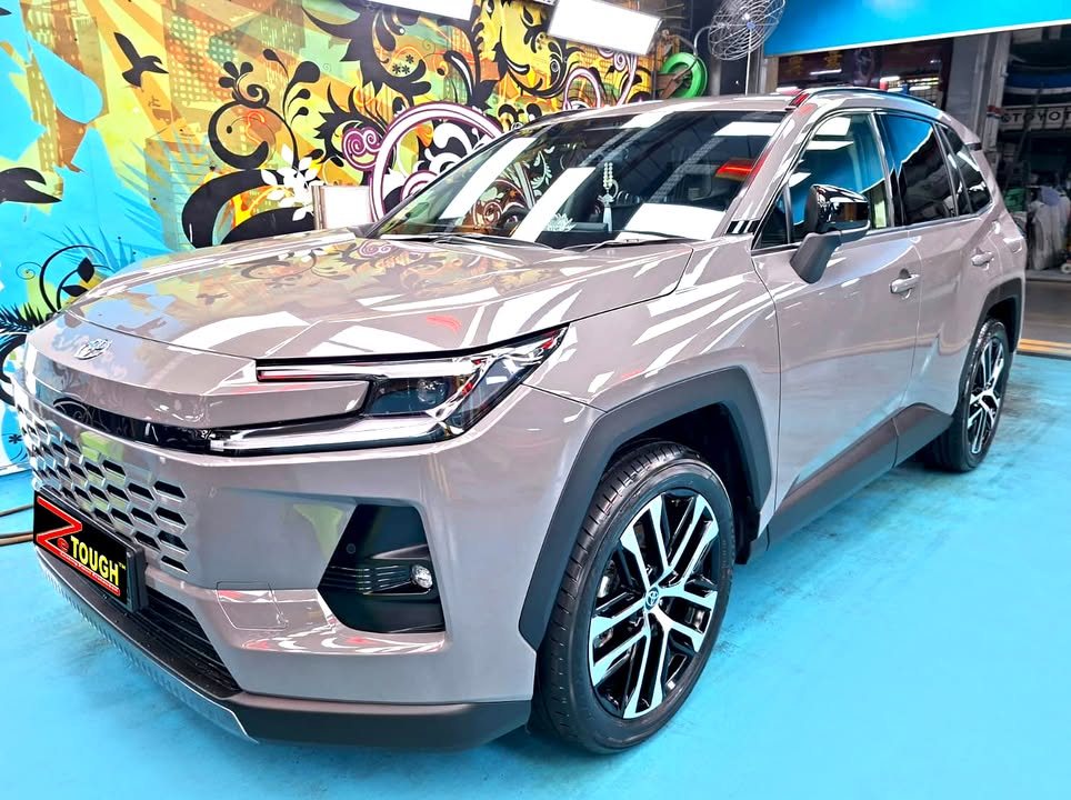 Grey Toyota RAV4, front three-quarter view in the workshop with a ZeTough plate on the bumper.
