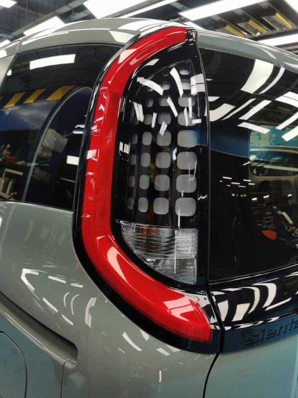 The coated bonnet of the Toyota Sienta under workshop lighting.