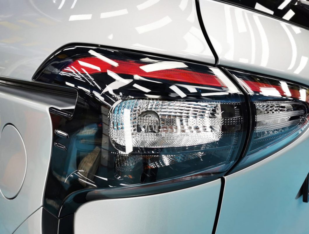 The coated bonnet of the Toyota Sienta under workshop lighting.