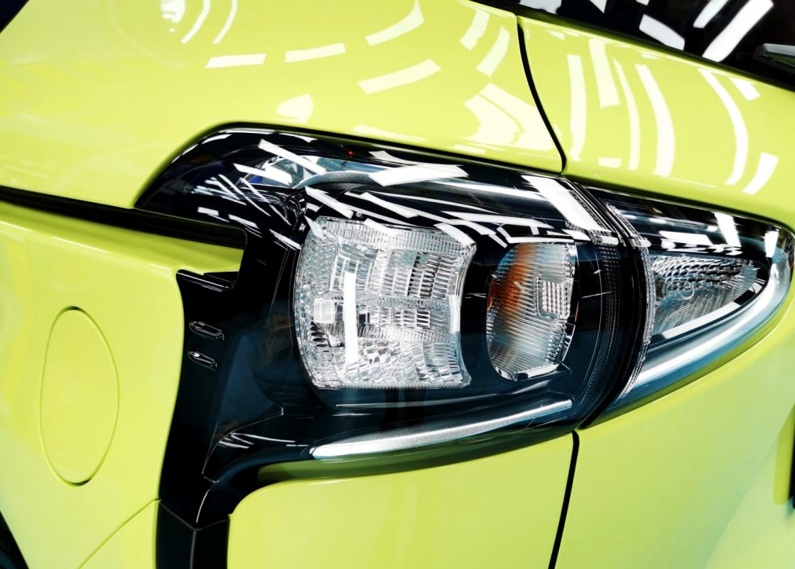 The coated bonnet of the Toyota Sienta under workshop lighting.