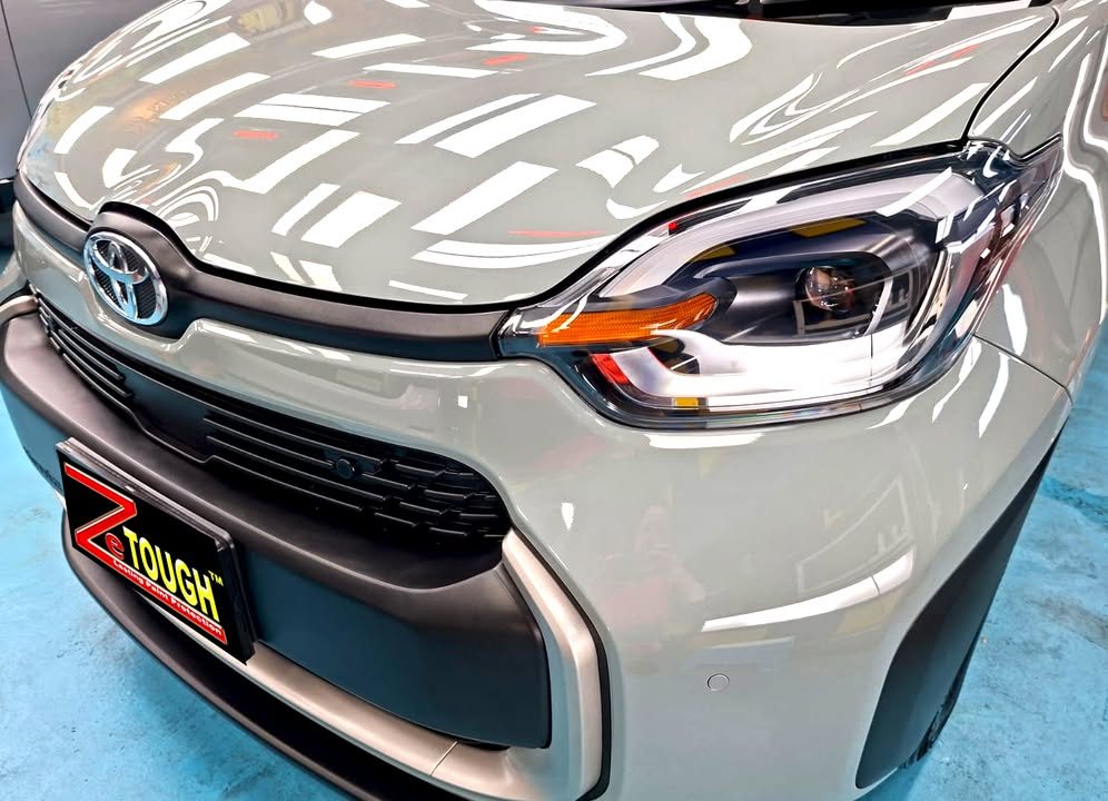 Front of the grey Sienta showing the grille, headlamp and bonnet gloss.