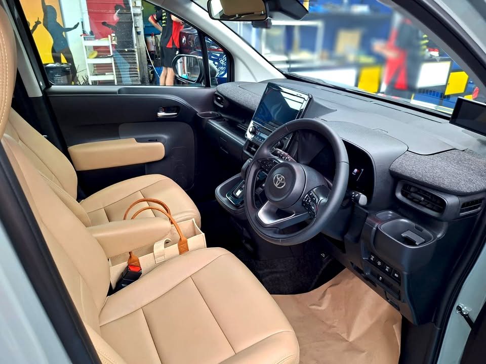 Front cabin of the Sienta with beige seats and dashboard screen.