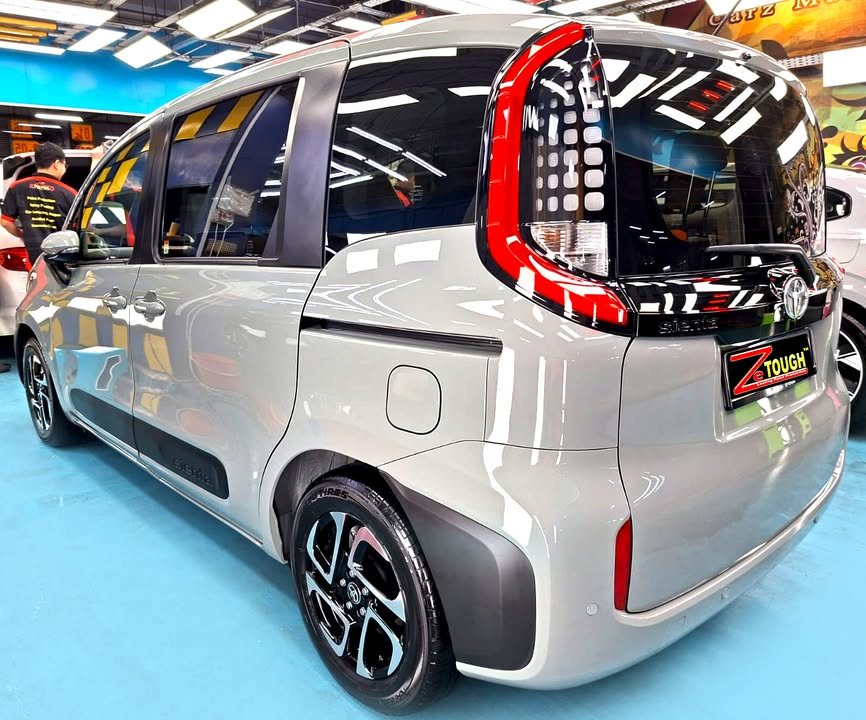 Rear three-quarter view of the grey Toyota Sienta.