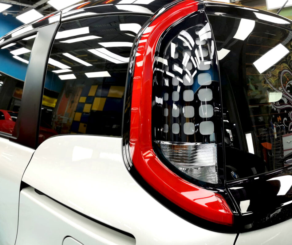 The coated bonnet of the Toyota Sienta under workshop lighting.