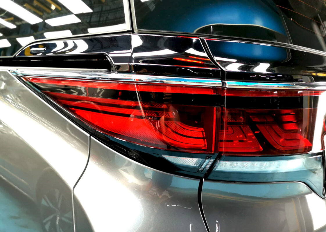 The coated bonnet of the Toyota Vellfire under workshop lighting.