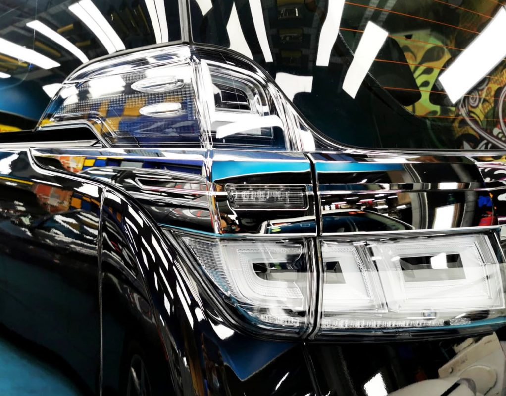 The coated bonnet of the Toyota Vellfire under workshop lighting.
