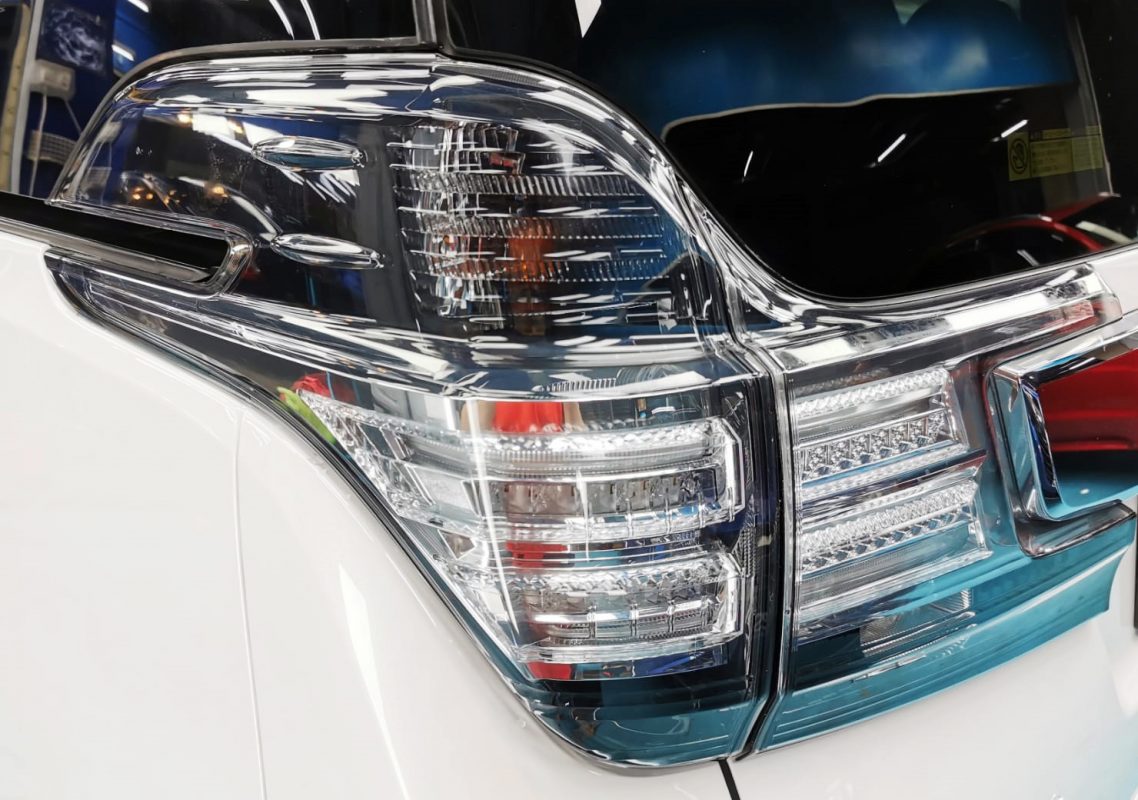 The coated bonnet of the Toyota Vellfire under workshop lighting.