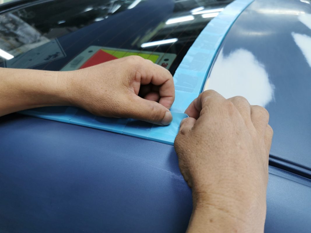 Non-painted surfaces being masked off on the Vios before spraying.