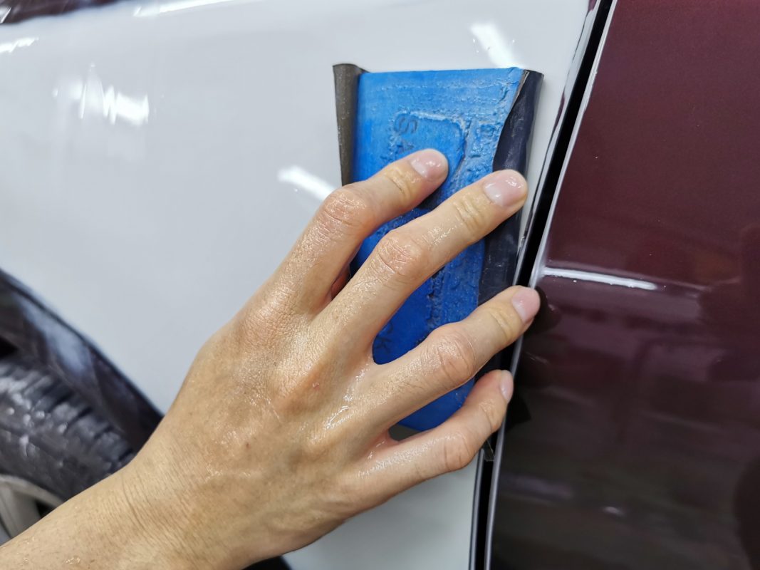 Wet-sanding the Vios's panels to smooth the surface.