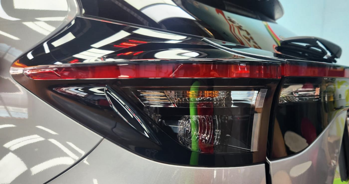 The coated bonnet of the Toyota Yaris under workshop lighting.