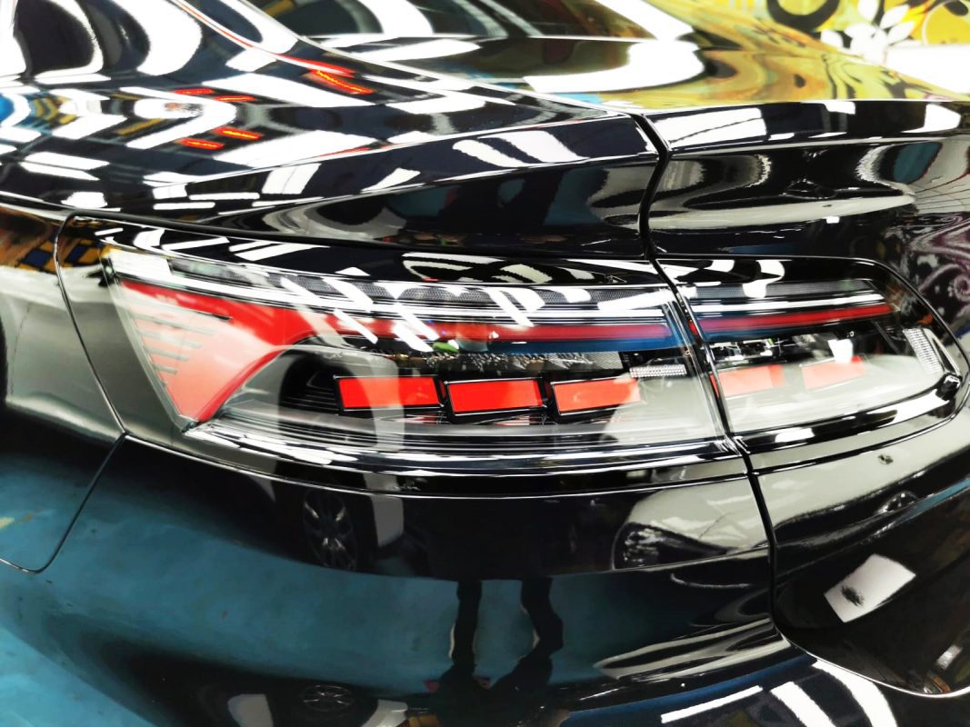 The coated bonnet of the Volkswagen Arteon under workshop lighting.