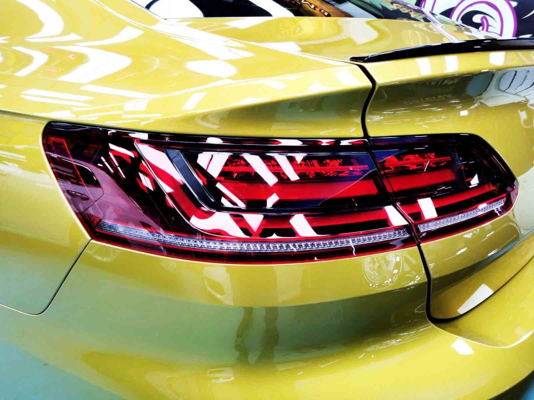 The coated bonnet of the Volkswagen Arteon under workshop lighting.