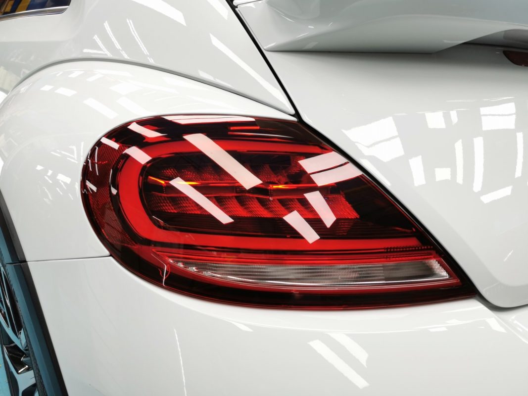 The coated bonnet of the Volkswagen Beetle Dune under workshop lighting.