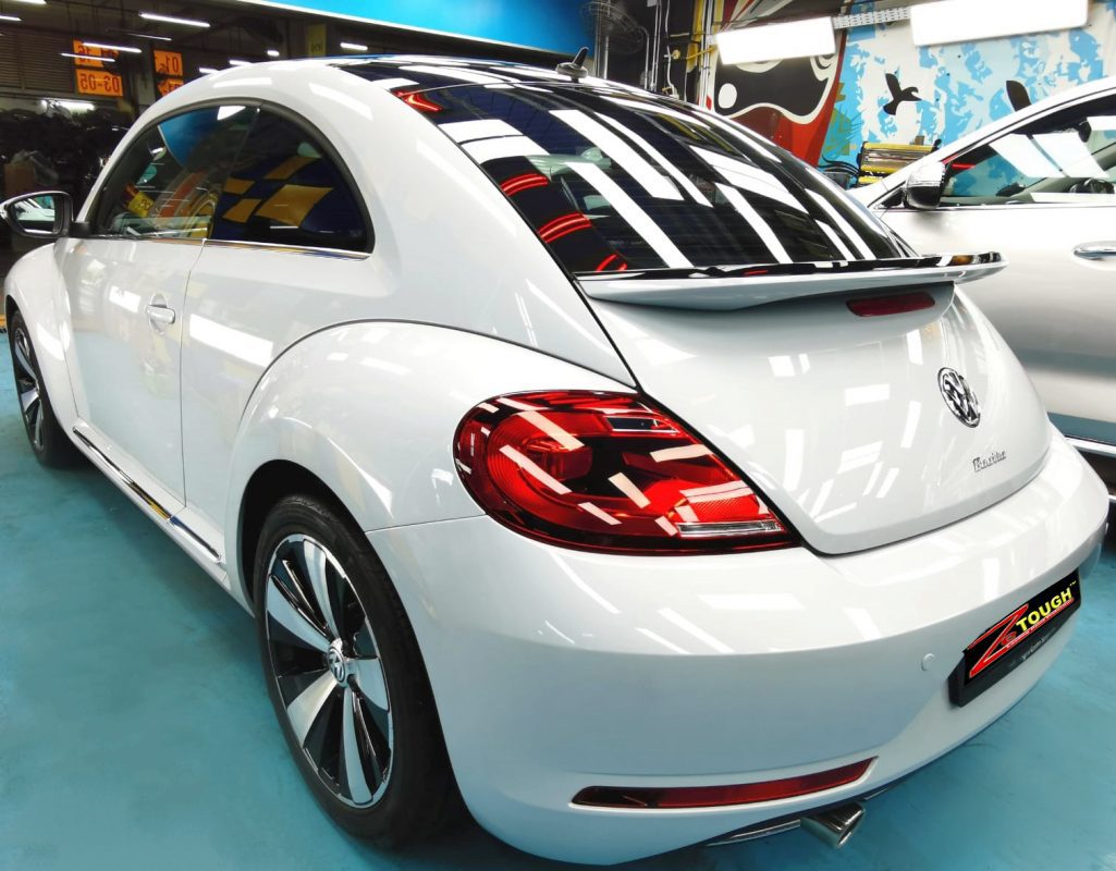 Rear quarter of the Volkswagen Beetle, glossy and protected.