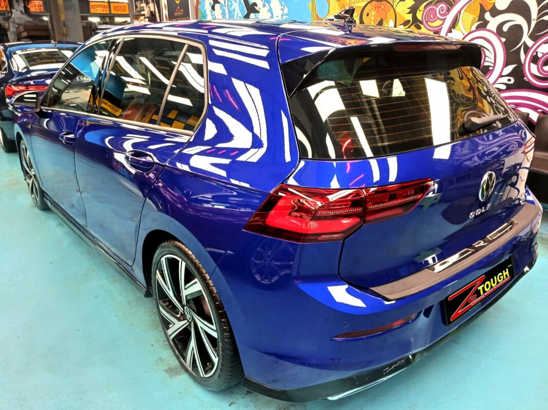 The coated bonnet of the Volkswagen Golf under workshop lighting.