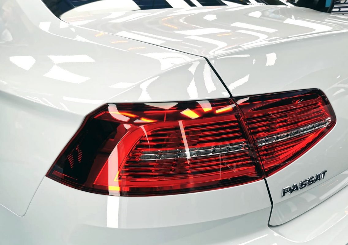 The coated bonnet of the Volkswagen Passat under workshop lighting.