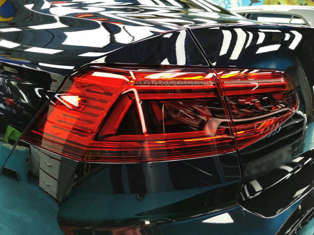 The coated bonnet of the Volkswagen Passat under workshop lighting.
