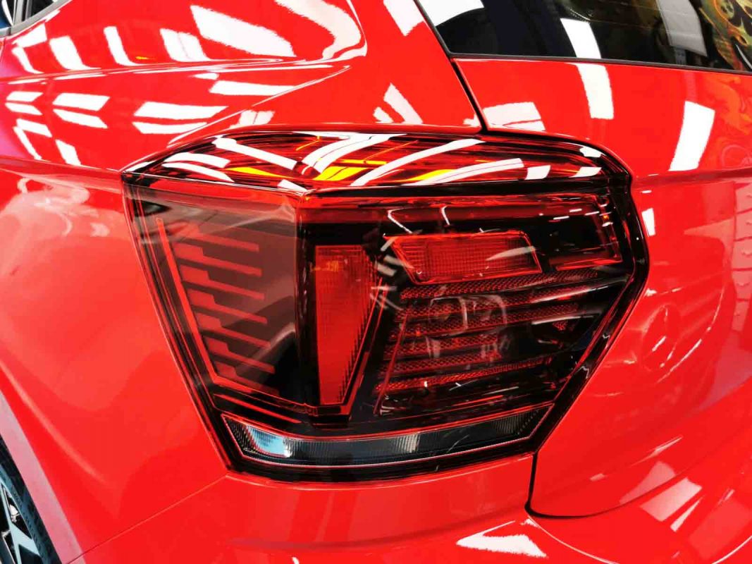 The coated bonnet of the Volkswagen Polo under workshop lighting.