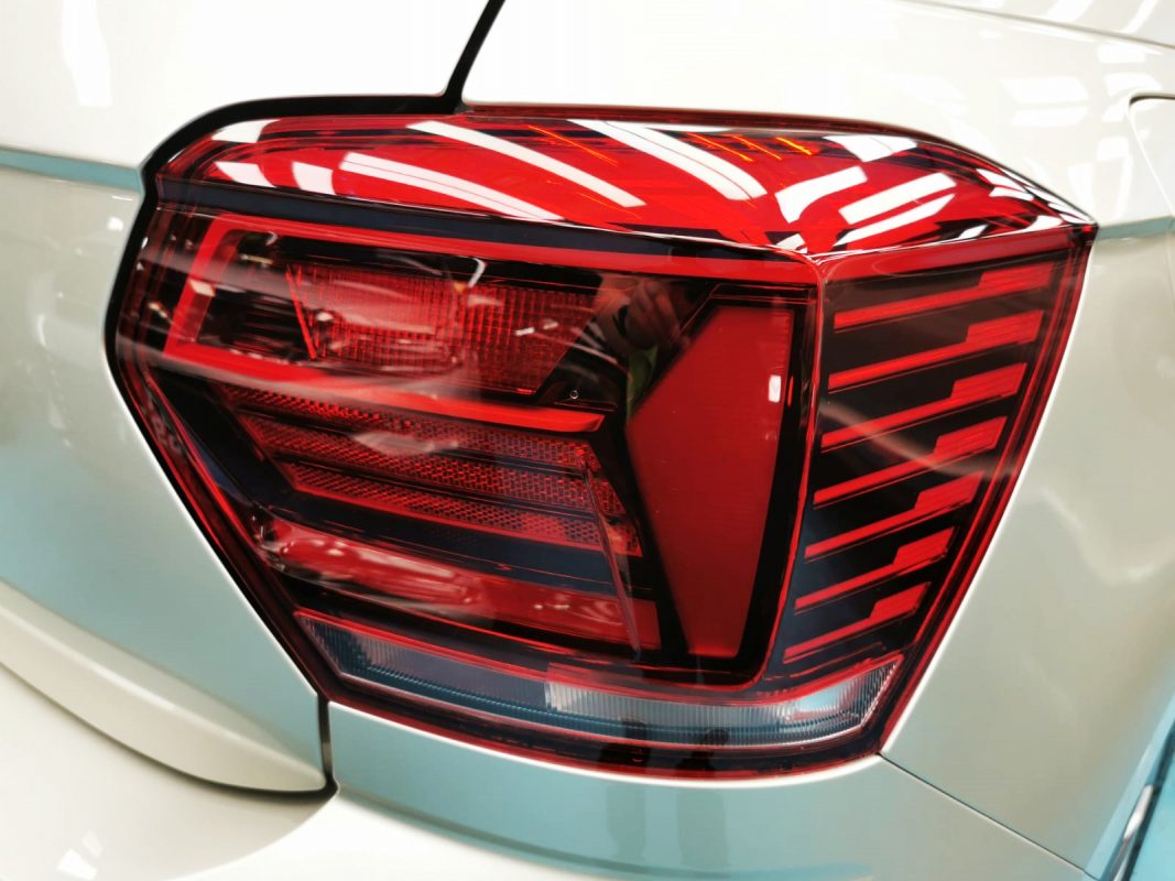 The coated bonnet of the Volkswagen Polo under workshop lighting.