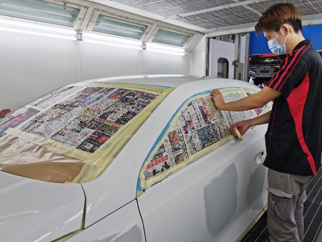 Non-painted surfaces being masked off on the Scirocco before spraying.