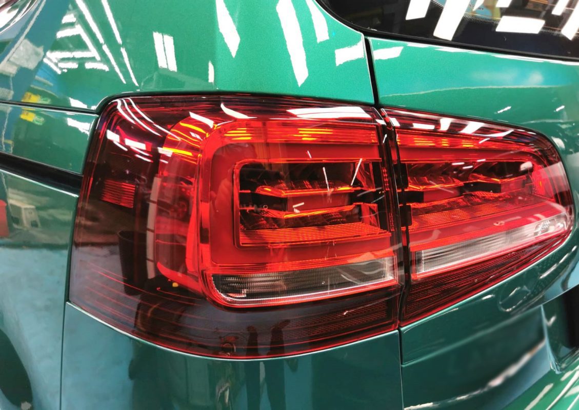 The coated bonnet of the Volkswagen Sharan under workshop lighting.