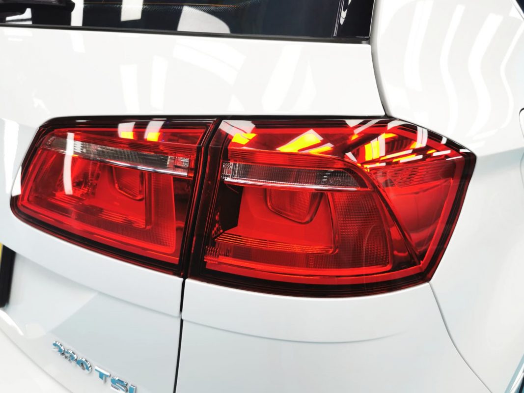 The coated bonnet of the Volkswagen Sportsvan under workshop lighting.