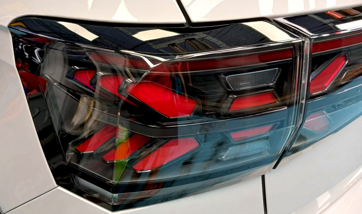 The coated bonnet of the Volkswagen T-Cross under workshop lighting.