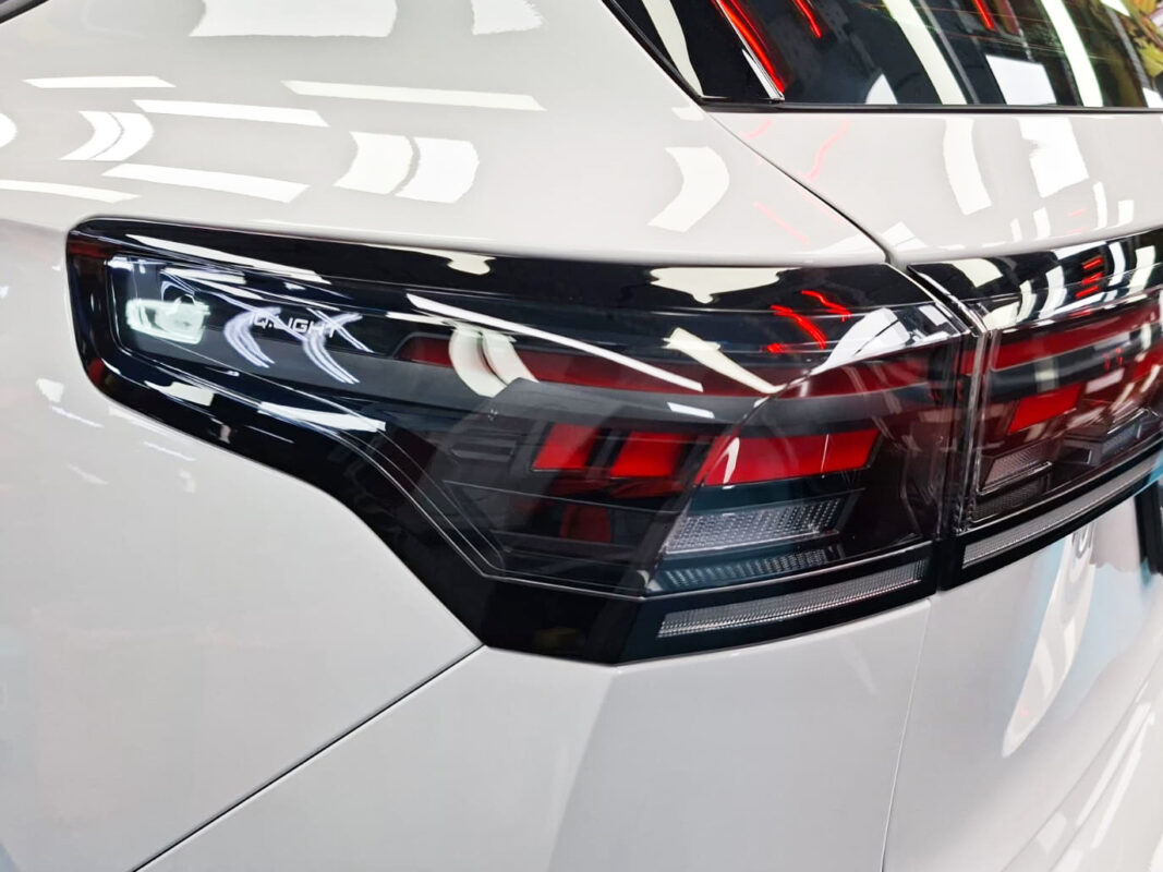 The coated bonnet of the Volkswagen Tiguan under workshop lighting.