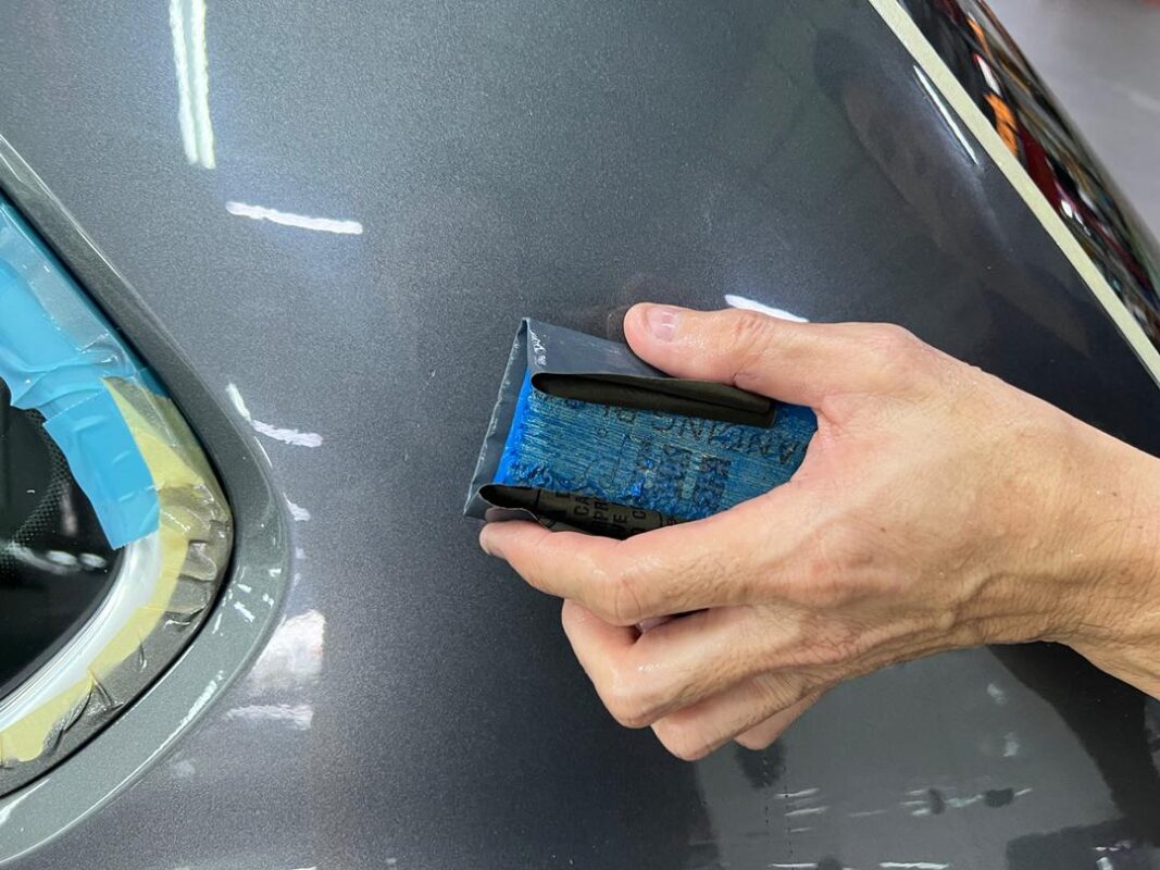 Close-up of a panel being wet-sanded on the Tiguan.