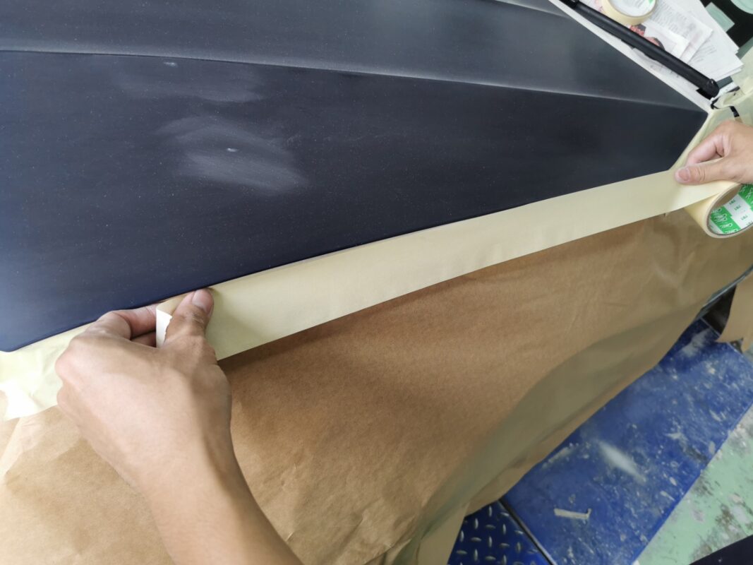 The Volkswagen Tiguan's panels masked with paper and tape before the spray booth.