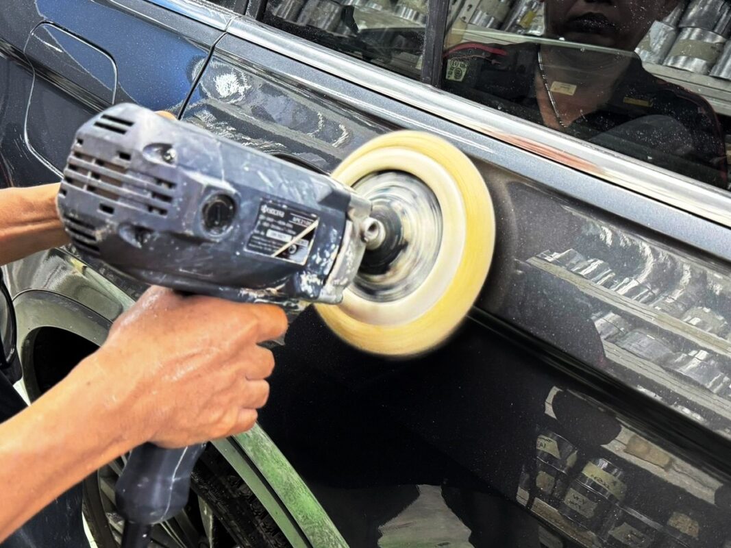 A Revol Carz technician inspecting the Tiguan's finish after spraying.