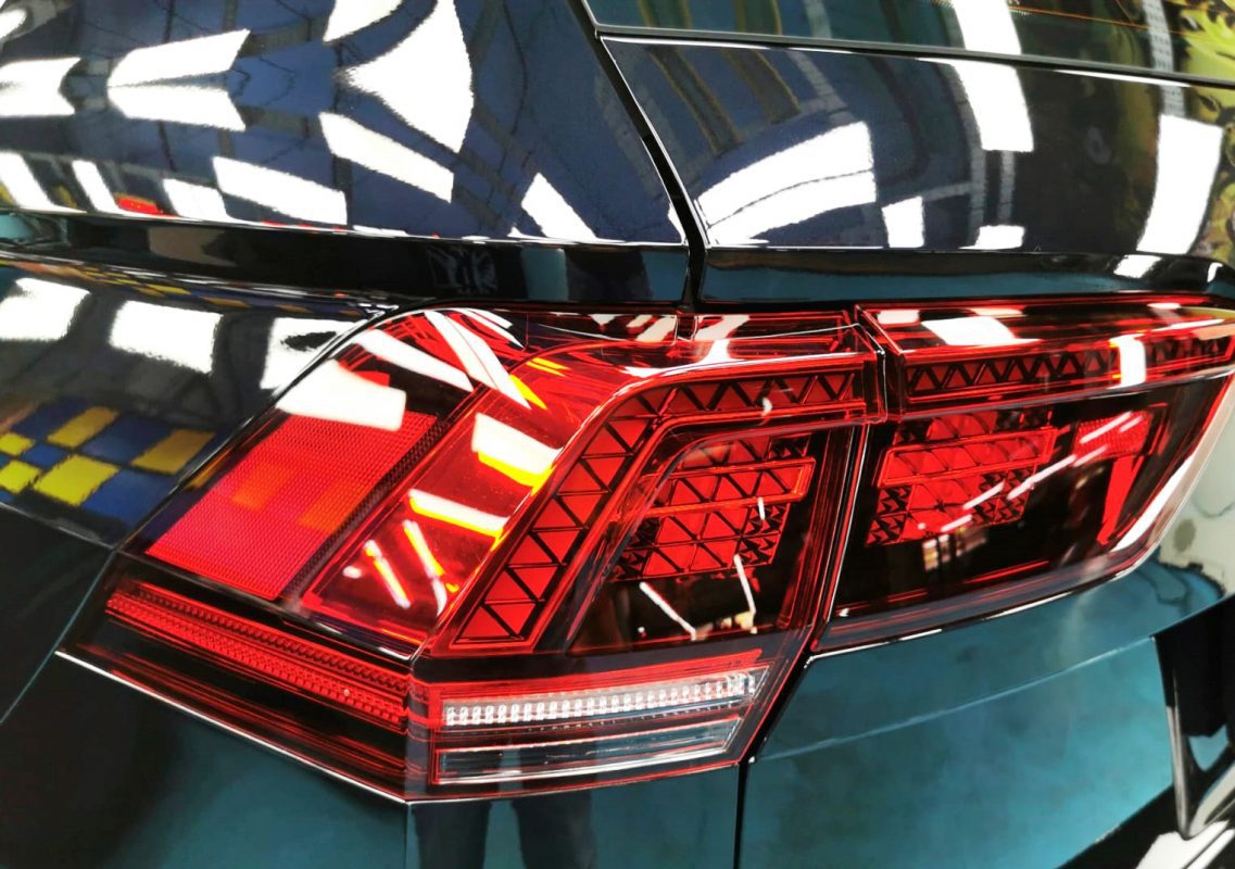 The coated bonnet of the Volkswagen Tiguan under workshop lighting.