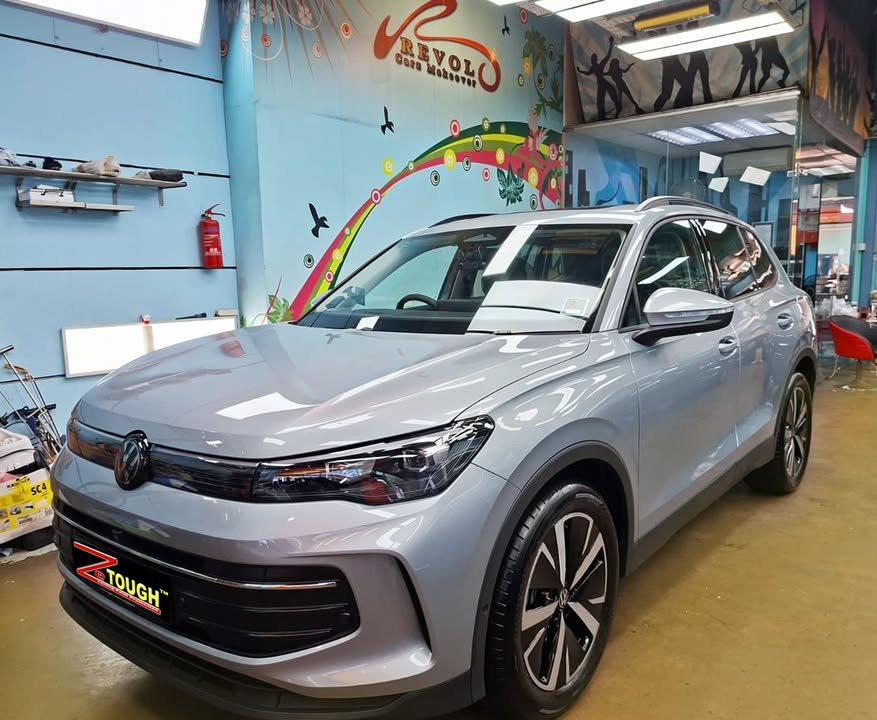 Silver grey Volkswagen Tiguan, front three-quarter view, in the Revol Carz workshop after coating.