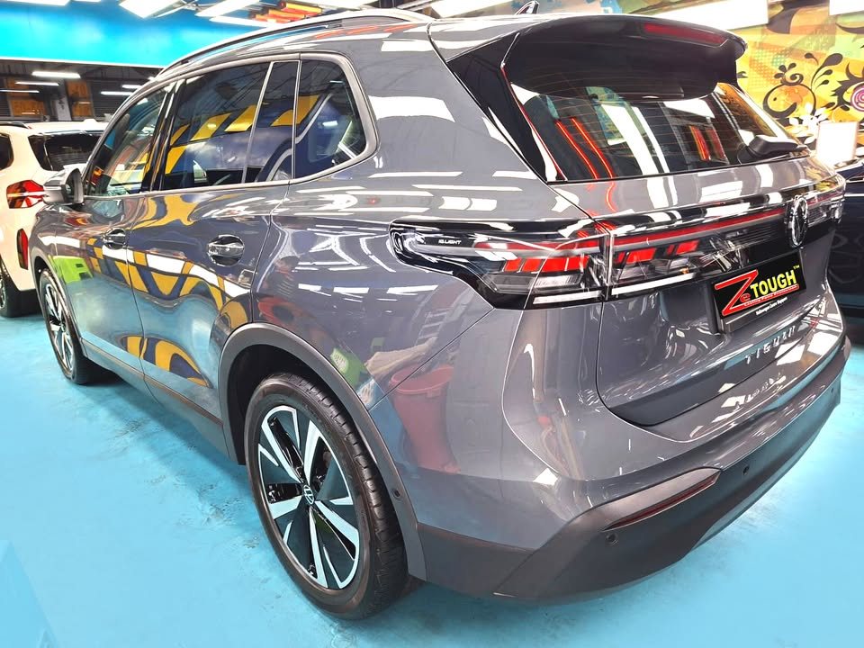 Rear three-quarter view of the grey Volkswagen Tiguan showing the light bar across the tailgate.