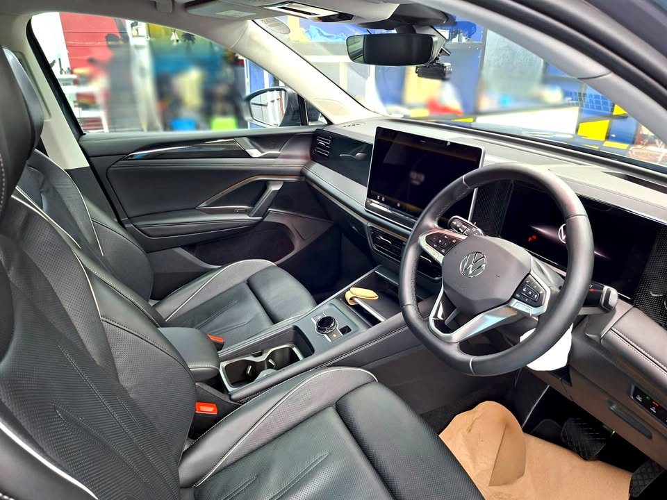 Interior of the Volkswagen Tiguan with black leather seats, steering wheel and centre screen.