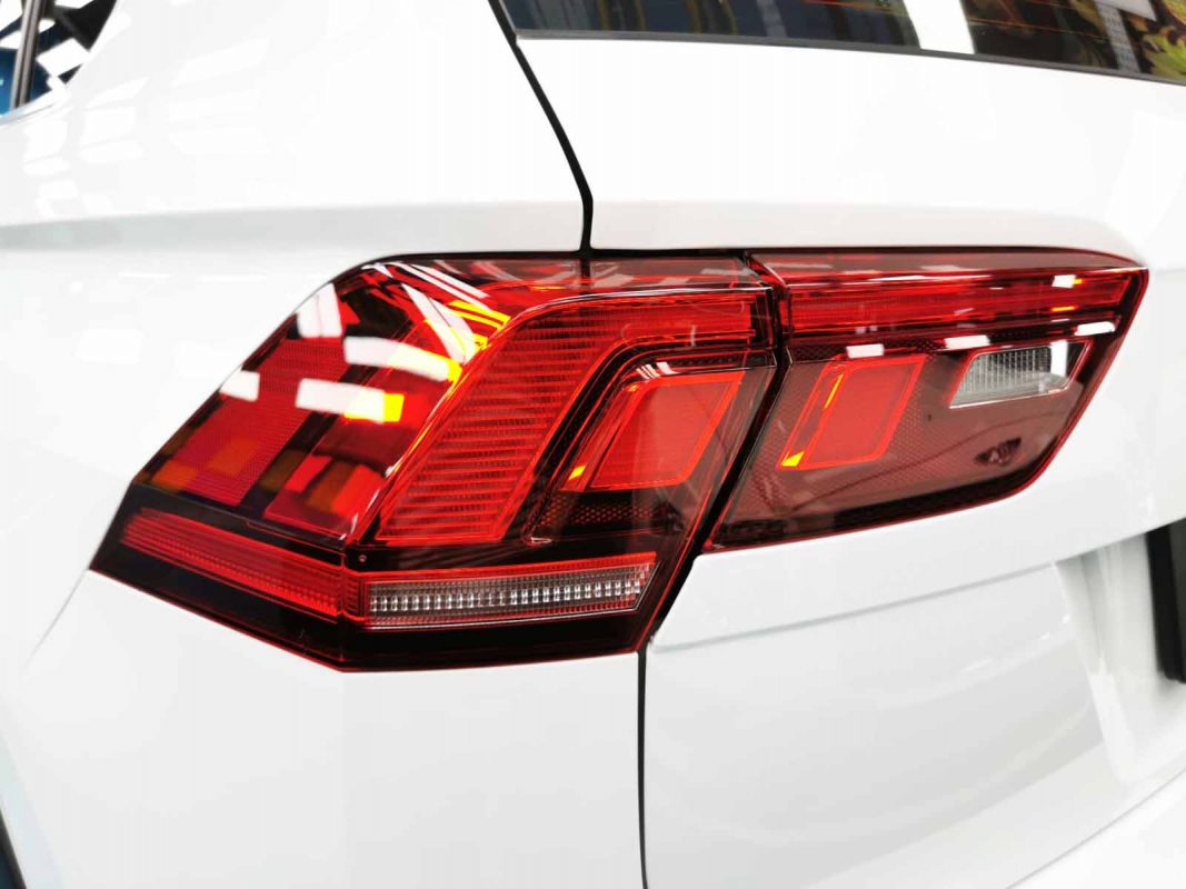 The coated bonnet of the Volkswagen Tiguan under workshop lighting.